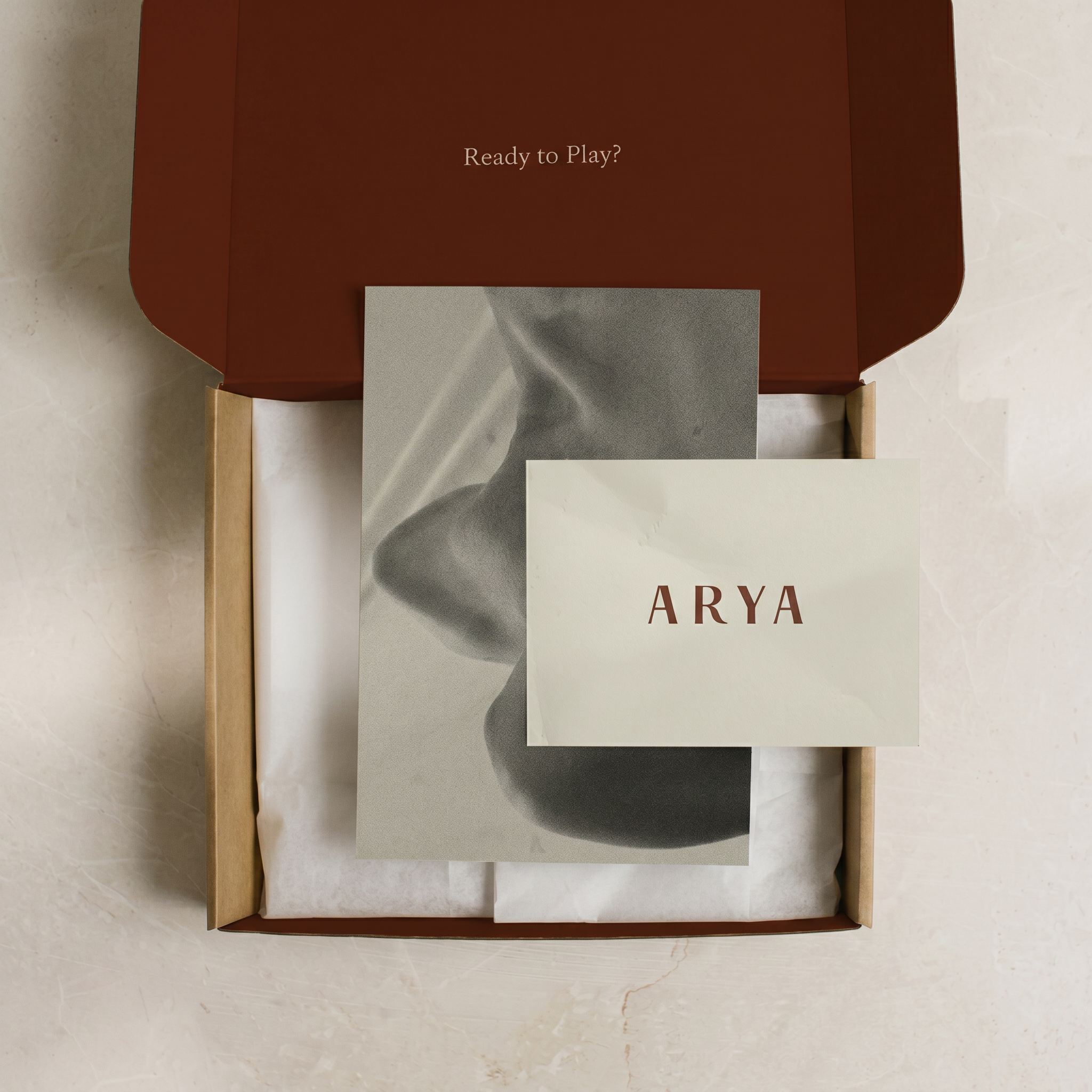 An open Arya box with the welcome card and silk ribbon detail